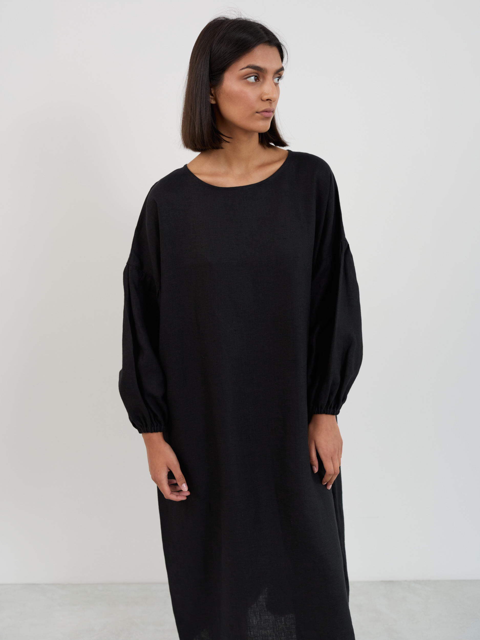 Close-up front view of the Briar black linen dress showing boat neckline, drop-shoulder seam, and elastic-cuff balloon sleeves
