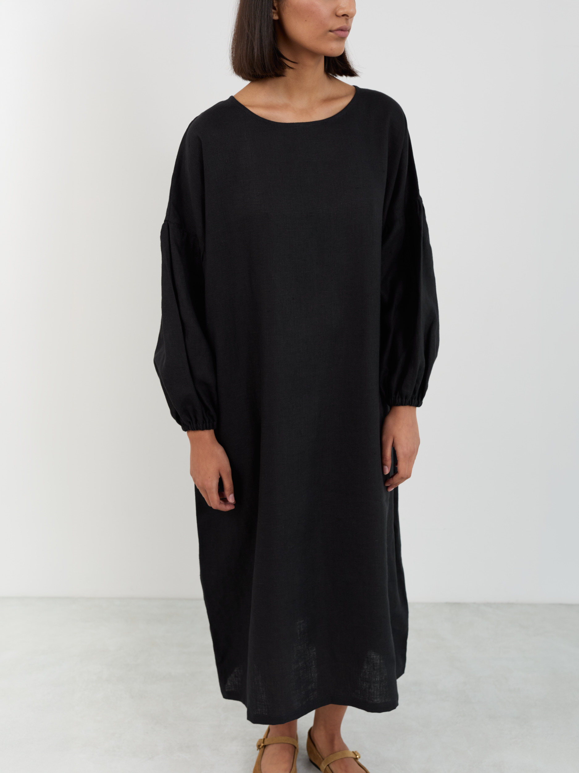 Front view of the Briar black linen dress, arms at sides, showing mid-calf length and slight A-line drape at the hem