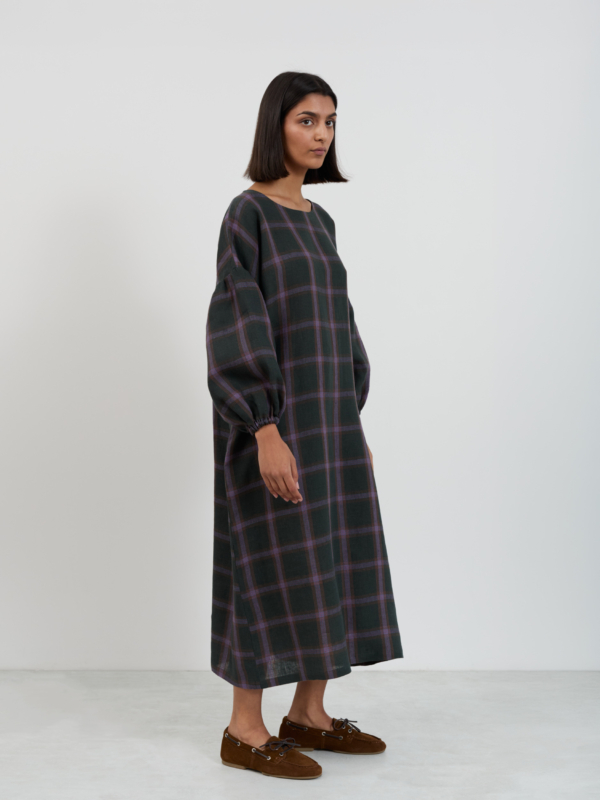 Three-quarter side view of the Briar linen midi dress in purple plaid windowpane pattern showing balloon sleeves and mid-calf length