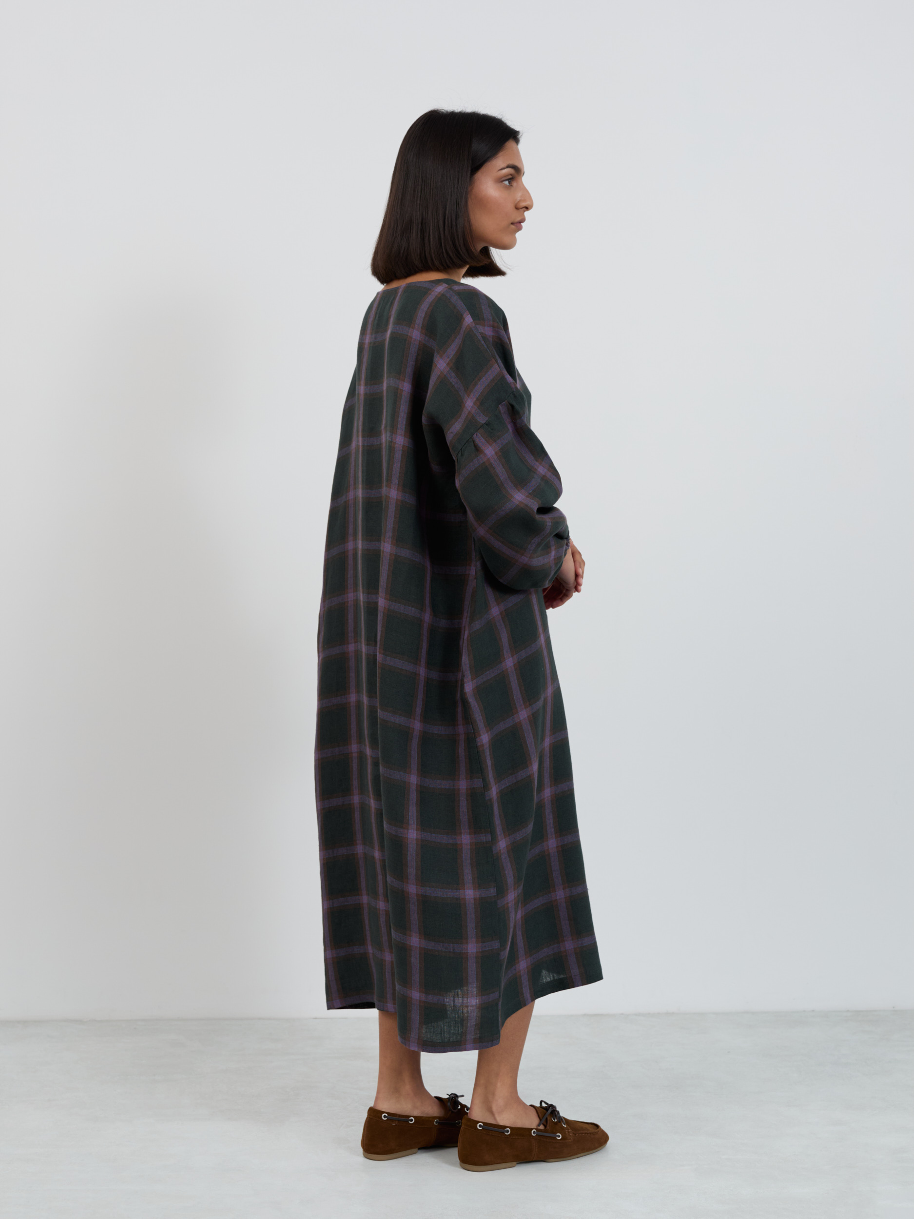 Full front view of the Briar linen midi dress in purple plaid showing oversized straight cut from boat neckline to mid-calf hem