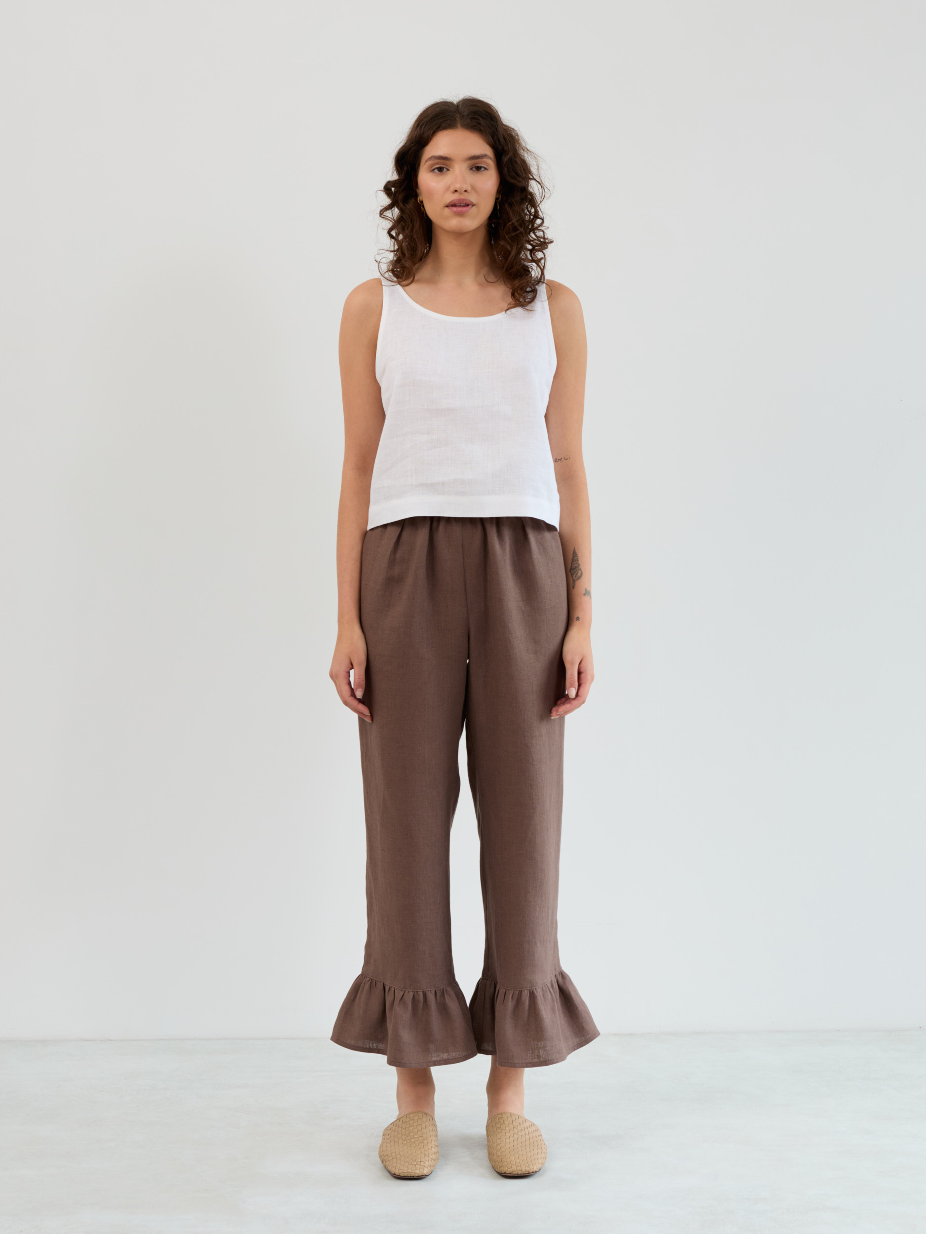 Front full-length view of the Gigi high-waist linen pants in cocoa with elastic waistband and wide ruffle flounce hem