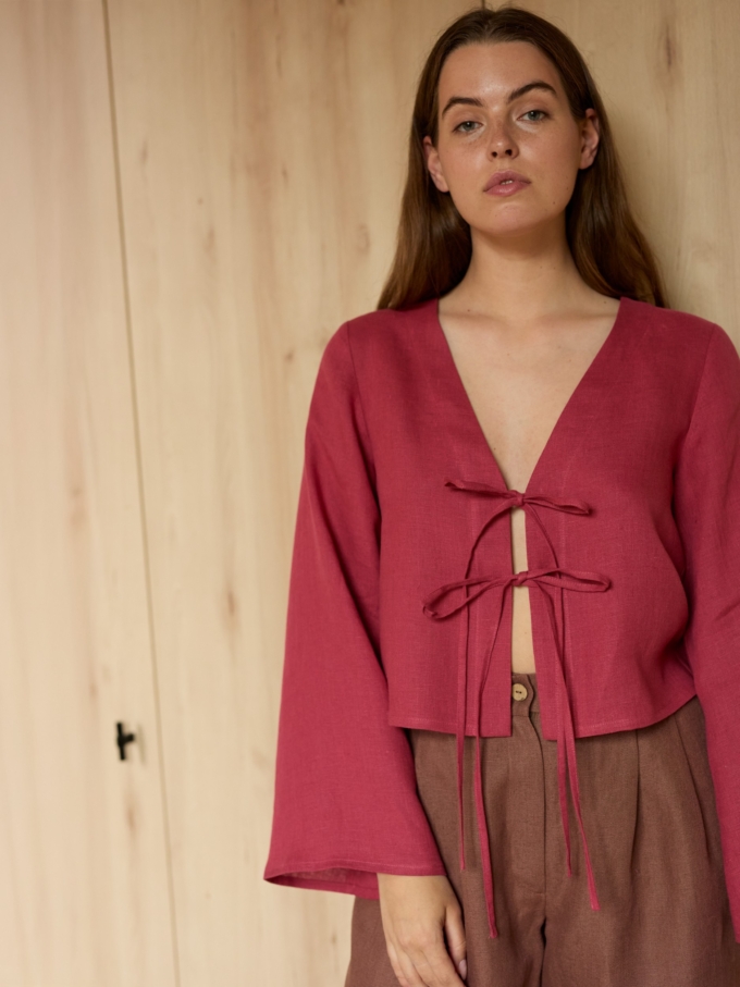 Image 1 of CASSIDY cropped linen top in Raspberry, featuring a tie-front closure, deep V-neck, and long bell sleeves, from Love and Confuse.