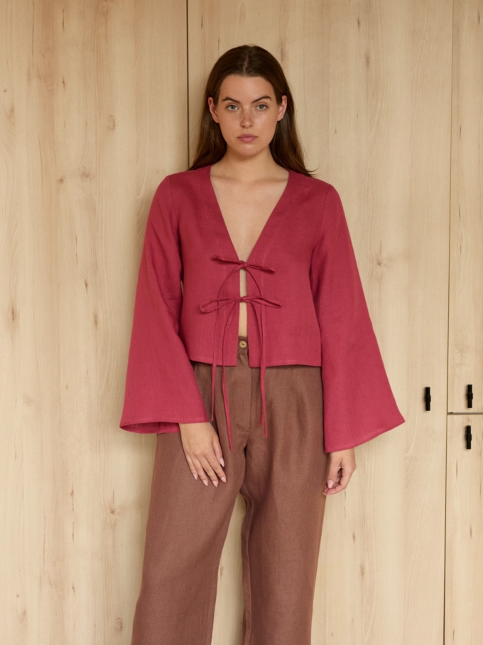 Image 2 of CASSIDY cropped linen top in Raspberry, featuring a tie-front closure, deep V-neck, and long bell sleeves, from Love and Confuse.